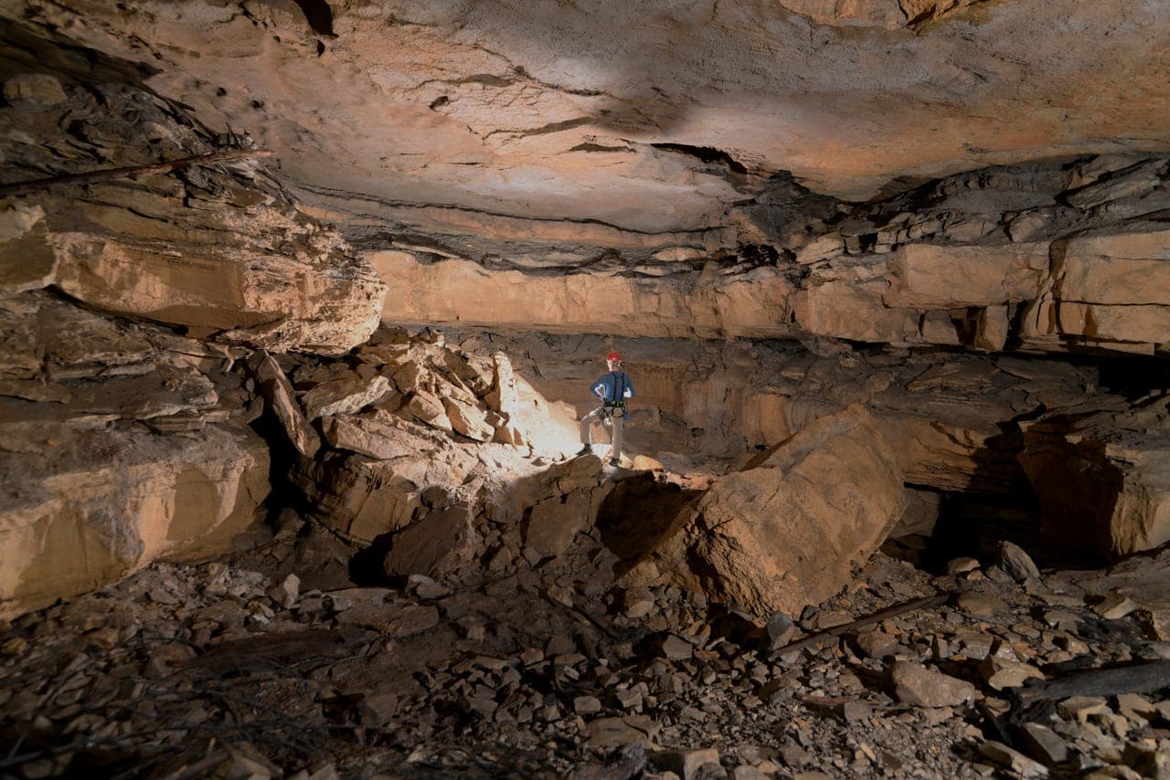 Caver standing in an expansive entrance room
