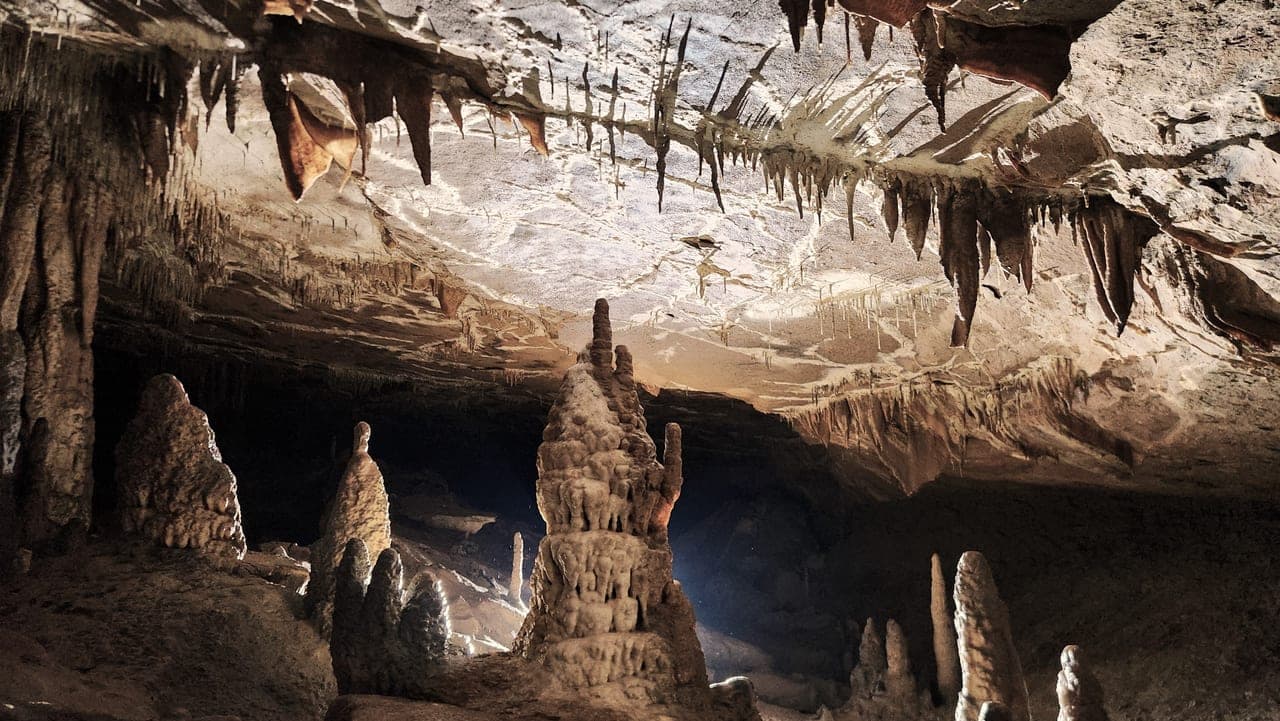 Wide chamber with dramatic stalagmites and ceiling formations